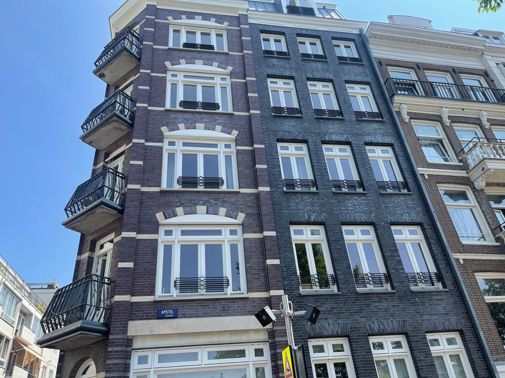 Amsterdams hoekpand met alle kozijnen en balkons opnieuw wit geschilderd