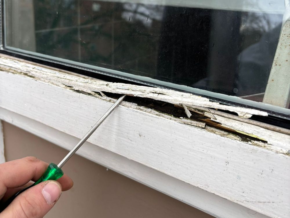 Kozijn wordt met een schroevendraaier aangeprikt om houtrot op te sporen